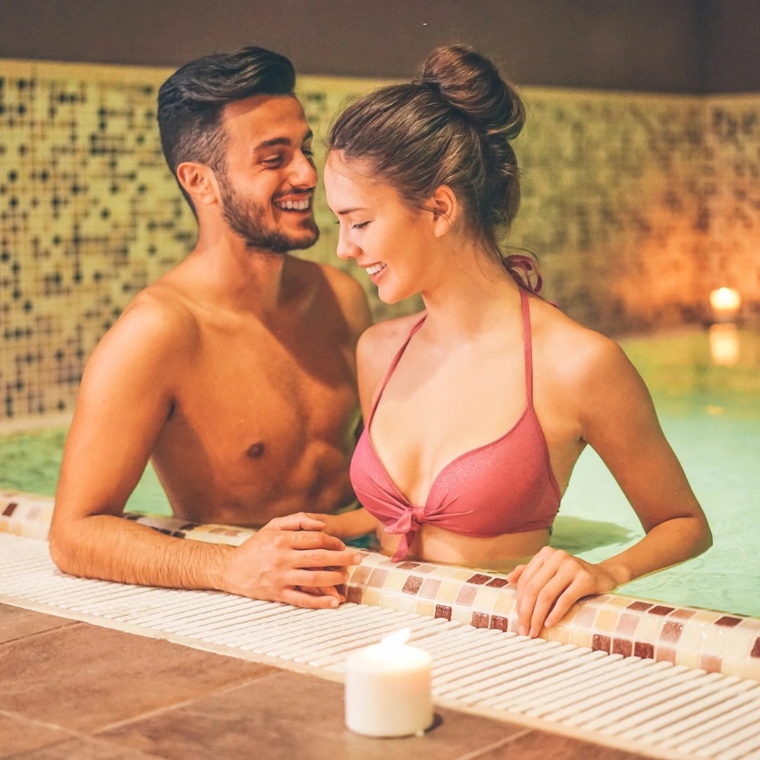 Couple, man and woman smiling are close together in the pool